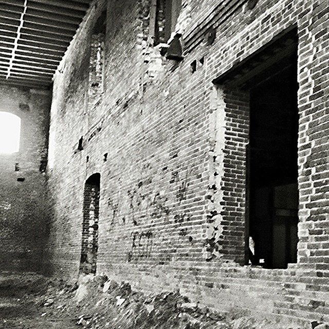 architecture, built structure, building exterior, brick wall, building, old, abandoned, wall - building feature, window, damaged, obsolete, weathered, run-down, low angle view, deterioration, stone wall, residential building, residential structure, house, day