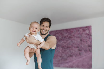 Father holding baby girl at home