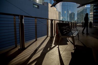 Shadow of person walking on railing in city