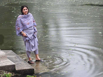 Portrait of young woman standing in lake