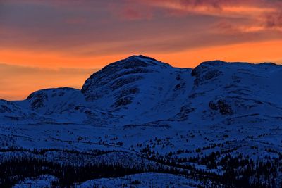 Scenic view of snowcapped mountains against dramatic sky