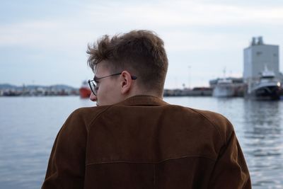 Rear view of man looking at sea against sky