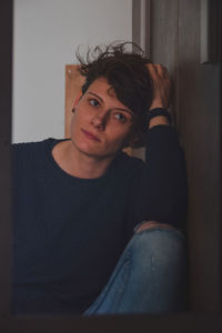 Portrait of young man sitting at home