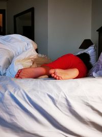 Midsection of woman sleeping on bed