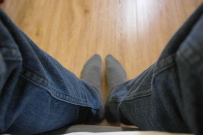 Low section of man relaxing on wooden floor