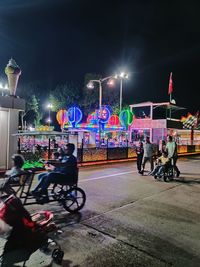 People riding motorcycle on road at night