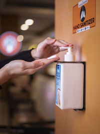 Cropped hands of woman using hand sanitizer