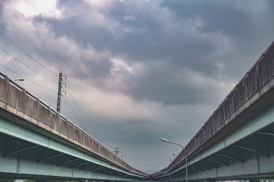 Low angle view of bridge and buildings against sky