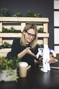 Young woman smiling while sitting on table