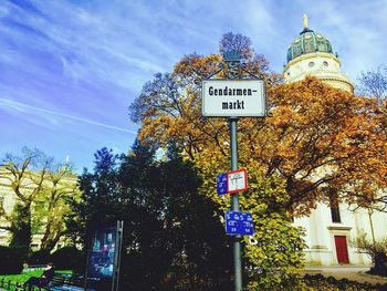 Low angle view of information sign against sky