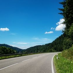 Empty road against blue sky