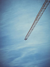 Low angle view of crane against sky