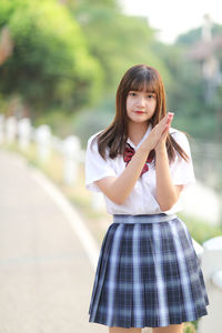 Young woman looking away while standing outdoors