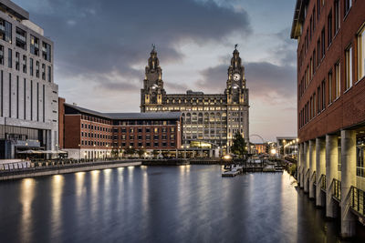 View of illuminated buildings against cloudy sky liverpool