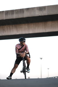 Man riding bicycle on bridge