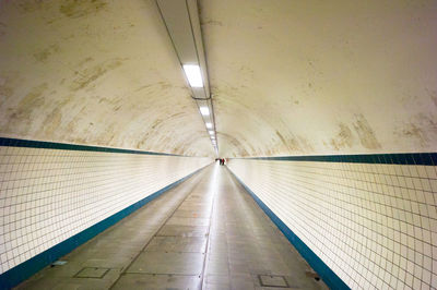 Empty road in tunnel along the walls