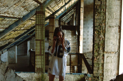 Young woman wearing sunglasses in abandoned building