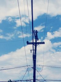 Low angle view of power lines against cloudy sky