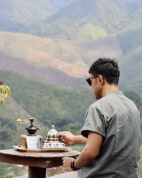 Side view of man drinking coffee at observation point