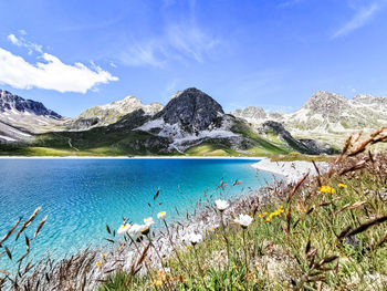 Scenic view of lake and mountains against blue sky