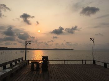 Pier on sea against sky during sunset