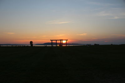 Scenic view of silhouette beach against sky during sunset