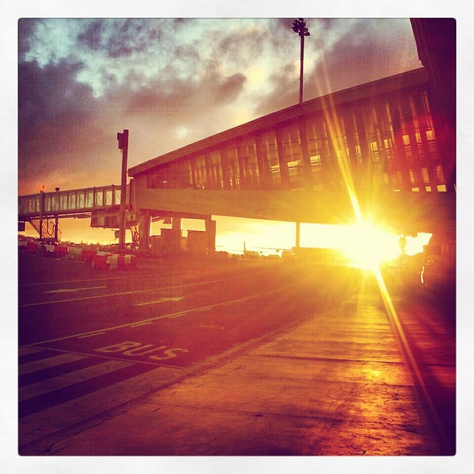 transfer print, sunset, sky, sun, auto post production filter, built structure, architecture, cloud - sky, sunbeam, sunlight, bridge - man made structure, connection, railing, cloudy, cloud, lens flare, orange color, building exterior, outdoors, bridge