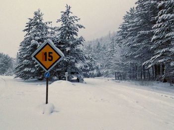 Road sign on snow covered land