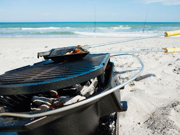 Boat moored on beach against sky