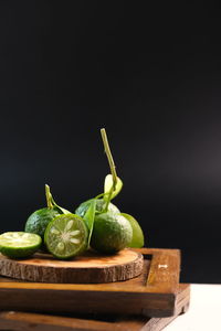 Close-up of fruits on table against black background