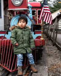 Portrait of cute boy standing behind the train