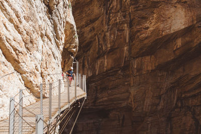 Low angle view of man climbing up against wall