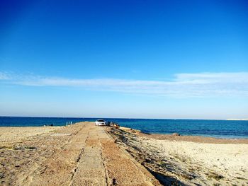 Scenic view of beach against blue sky