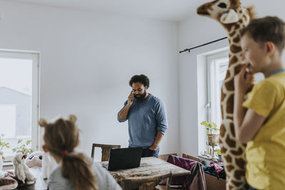 Man working from home and taking care of children