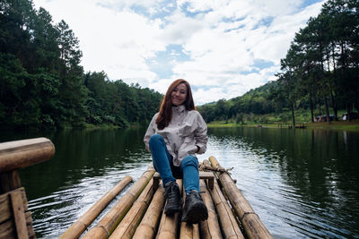 A female traveler sitting and riding bamboo raft in the lake