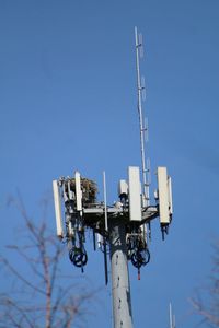 Low angle view of communications tower against clear blue sky