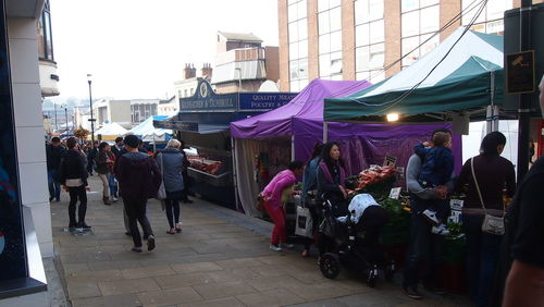 People in market against sky in city