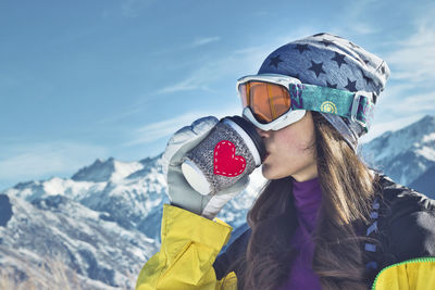 Portrait of woman with snowcapped mountains in winter