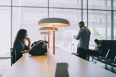 Rear view of people sitting on table