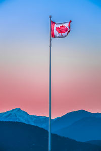 Red flag against mountain during sunset
