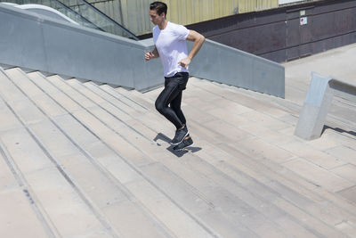 Full length of man jogging on steps outdoors