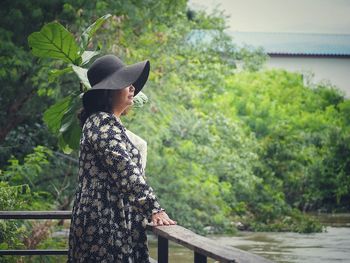 Midsection of woman standing by tree against plants