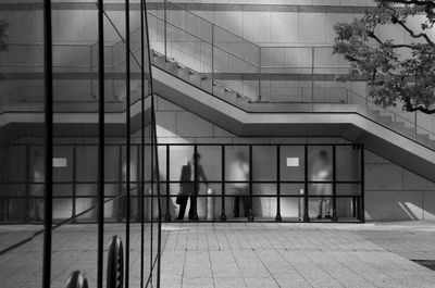 Man walking on footpath by modern building