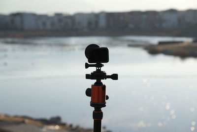 Close-up of camera on beach against sky