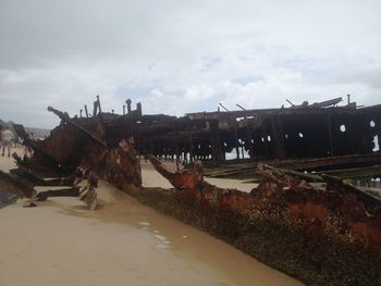 Abandoned built structure on beach against sky