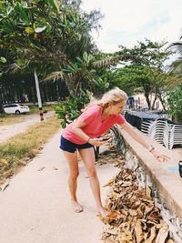 Full length of woman with umbrella against trees