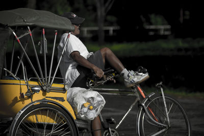 Man riding pedicab in city