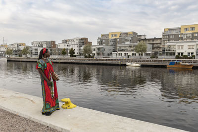 African woman looks across the river and wonders how housing prices will affect life under inflation