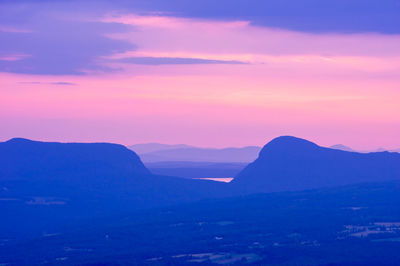 Scenic view of silhouette mountains against romantic sky at sunset