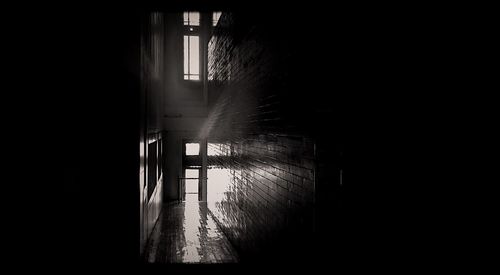 Empty alley amidst buildings in dark room